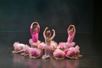 Bildet viser små ballettdansere på scenen. De har på seg rosa drakt og rosa strutteskjørt. 