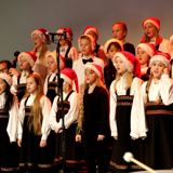 Bilde viser juniorkoret i ferd med å synge julekonsert. De har deres fine dress på.